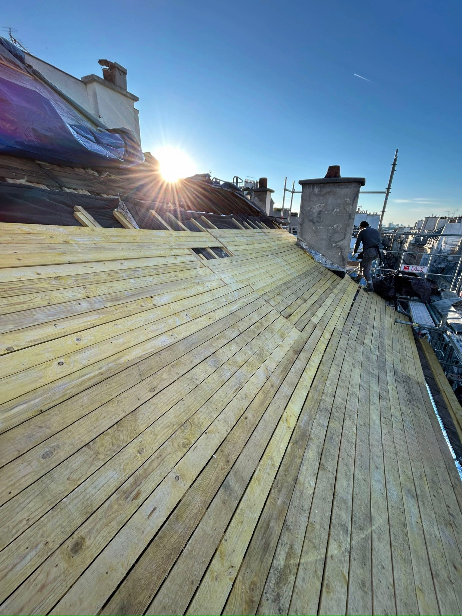 Chantier de voligeage au coucher du soleil par AD Couverture